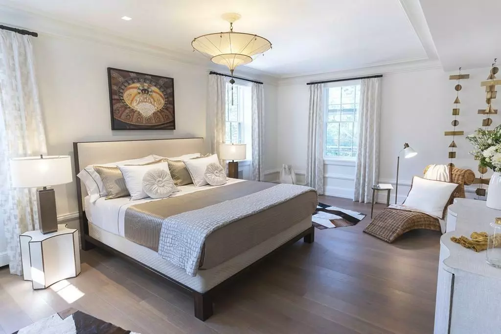 A bedroom in Boston with white walls and a cowhide rug.