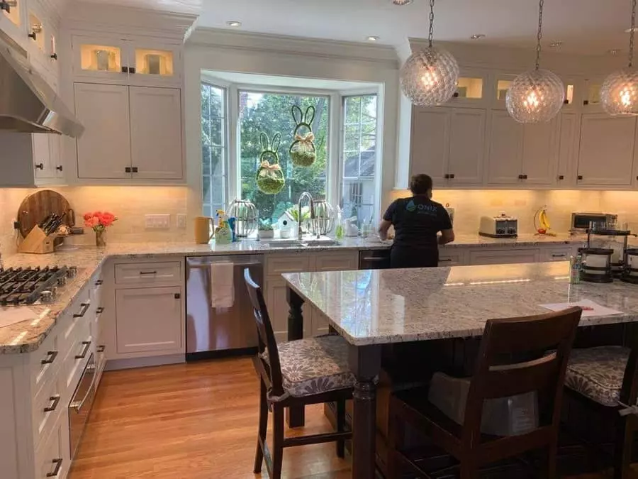 A kitchen with white cabinets and granite counter tops.