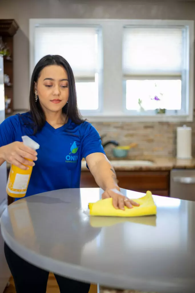 A woman wearing a blue shirt, providing cleaning services in Boston.