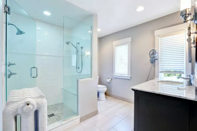 an image of a roomy bathroom featuring a light blue shower glass door; clean glass shower doors