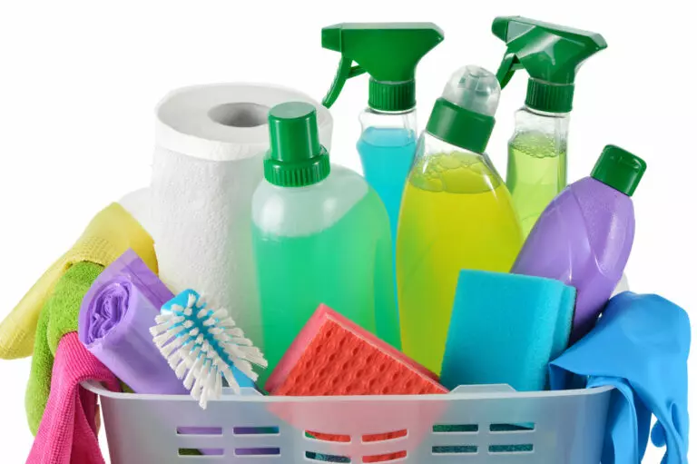 Kitchen Surface Cleaners ; an image of a white background with a basket overflowing with assorted cleaning products