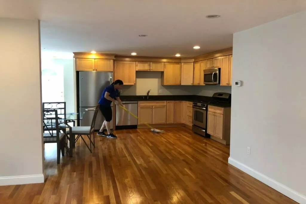 an image depicting a female Onix cleaner diligently scrubbing the kitchen floor with a mop
