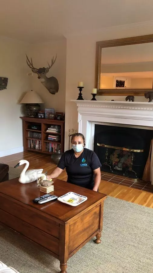 A masked man leisurely sitting in a living room, aptly representing the importance of staying protected during apartment cleaning.