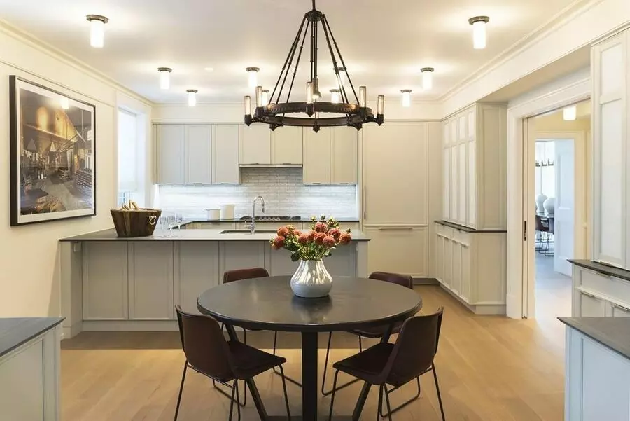A kitchen with a table and chairs and a chandelier, perfect for apartment cleaning.