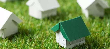 A group of paper houses on the grass, perfect for creating templates.
