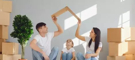 A family sitting on the floor surrounded by moving boxes after a professional move in and move out cleaning service in Boston.