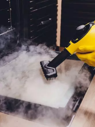Steam cleaning a floor to sanitize and remove grime, as outlined in our house cleaning checklist.