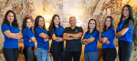 A team of eight uniformed employees standing confidently with their arms crossed, ready to apply their living room cleaning templates.