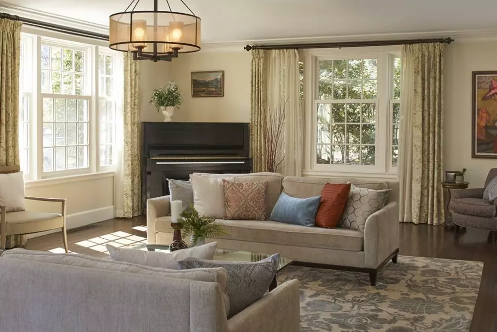 Elegant living room with a grand piano, comfortable seating, and large windows, ready for any special event with impeccable cleaning.