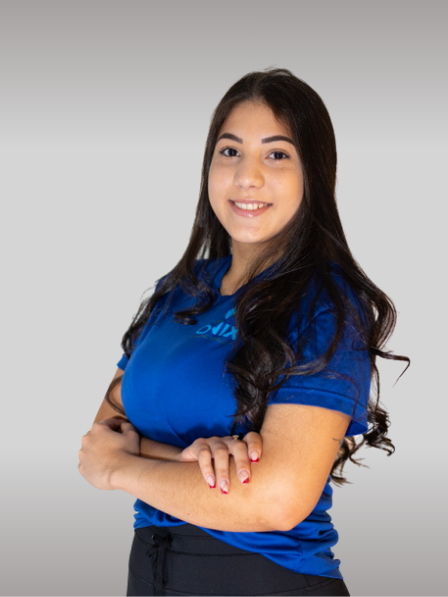 A woman with long dark hair, wearing a blue T-shirt, stands with her arms crossed and smiles at the camera. The background is a plain light gray, reflecting the professionalism of Onix Cleaning Services.